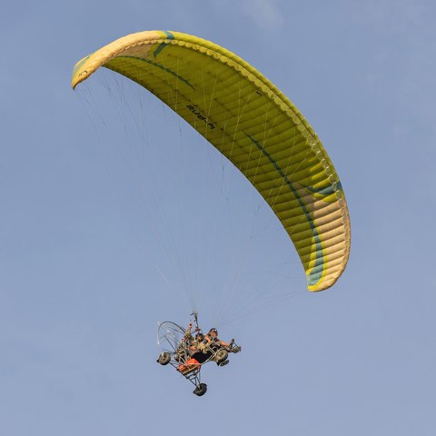 Two seater paramotor   Powered paragliding in flight   3 quarter view a sunny afternoon in Don Det Laos